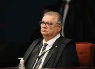 Dino proíbe saque em espécie de emendas e cobra regra do BC Ministro do STF Flávio Dino sentando dando atenção