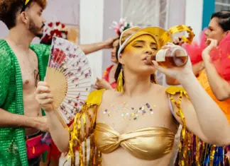 Ressaca ou intoxicação sinais de alerta no Carnaval Foliões em dia de calor com água na mão e alerta sobre sinais de intoxicação alcoólica no Carnaval