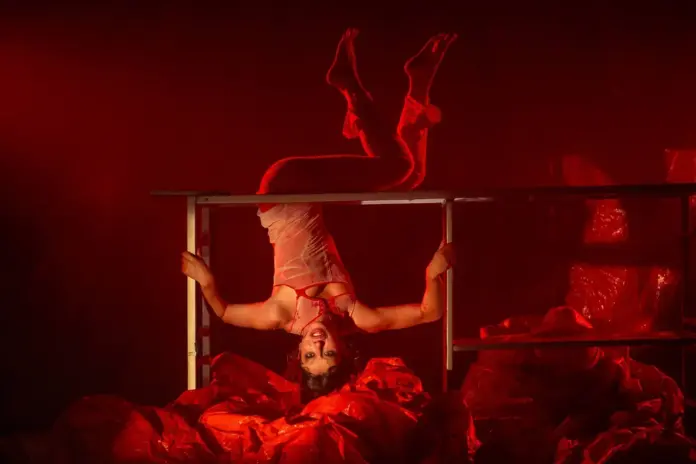 Mulher vestida de vermelho e de cabeça para baixo.