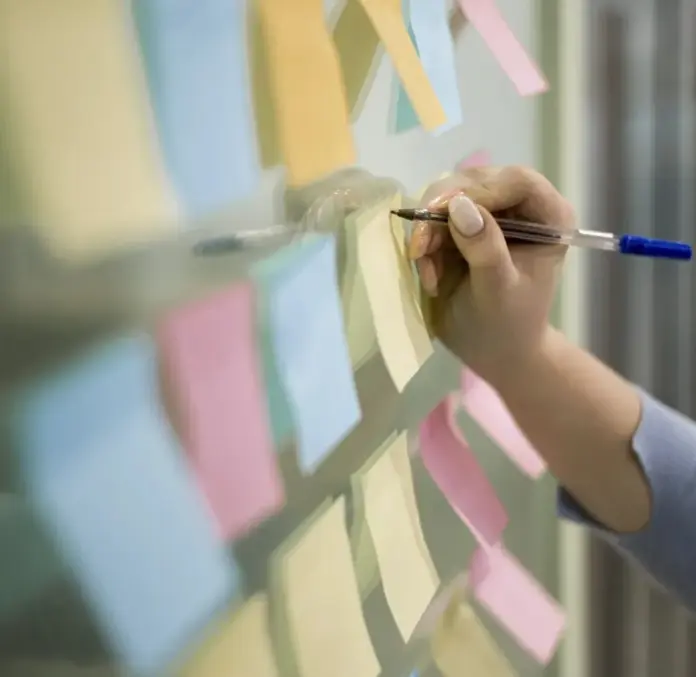 Planejar sonhos e organizar objetivos financeiros em um caderno com cálculos e planejamento financeiro pessoal.