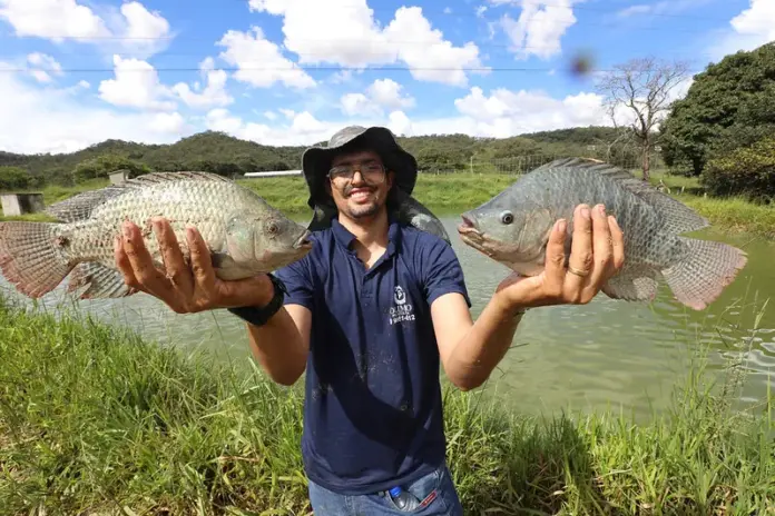 Psicultor apresentando 02 peixes em suas mãos