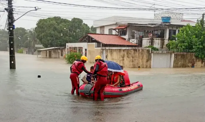 Bomeiros com bote em área alagada pela chuva