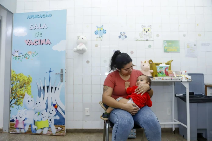 Bebê no colo da mãe para tomar vacina