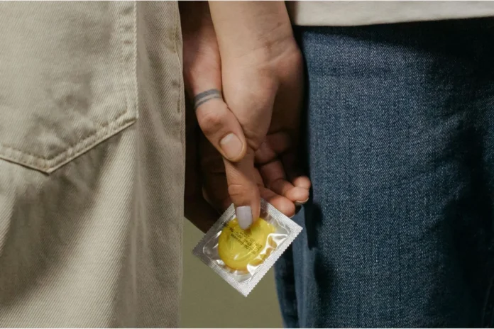 Mãos dadas com um preservativo